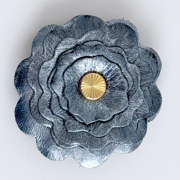 Gray flower-shaped object with a gold center on a white background