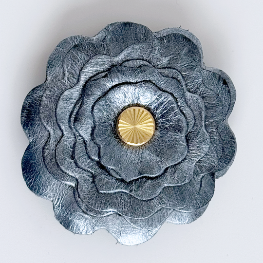 Gray flower-shaped object with a gold center on a white background