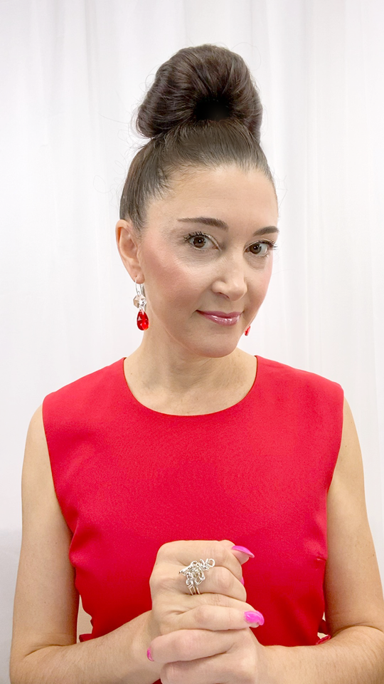 Designer, Lisa Ramos showcasing a the red earrings.  