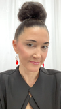 Designer, Lisa Ramos showcasing a the red earrings.  